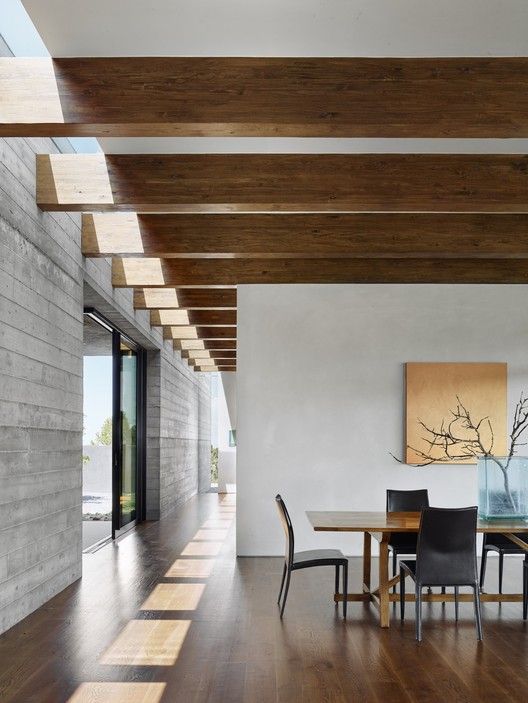 a dining room with wooden floors and white walls