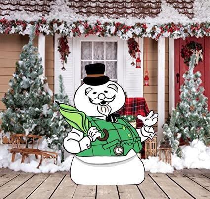 a snowman is standing in front of a house