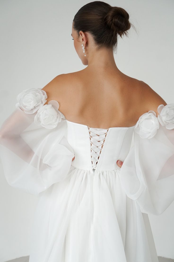 the back of a woman wearing a white dress