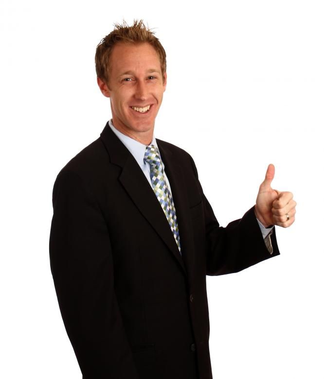 a man in a suit and tie giving the thumbs up sign with his right hand