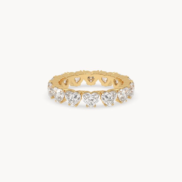 a yellow gold ring with hearts on the side and diamonds in the middle, set against a white background