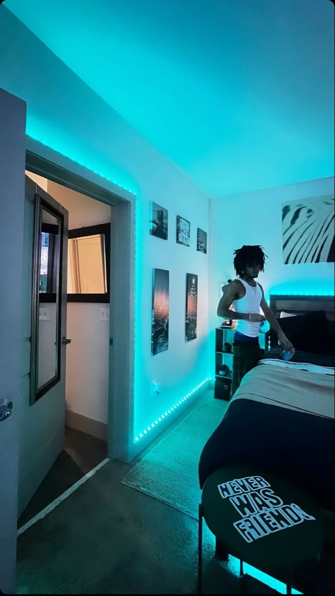 a woman standing next to a bed in a room with blue lights on the walls