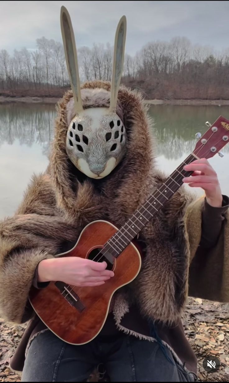 a person with an animal mask playing a guitar