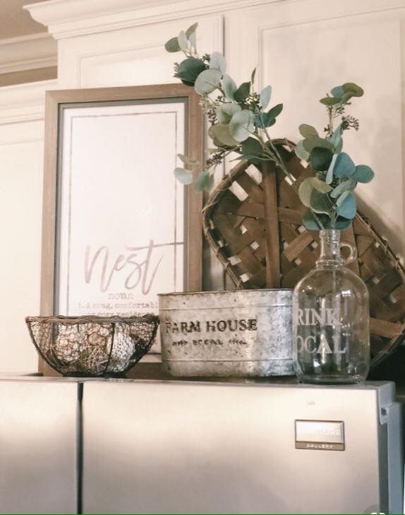 a metal refrigerator freezer sitting on top of a wooden shelf next to a basket