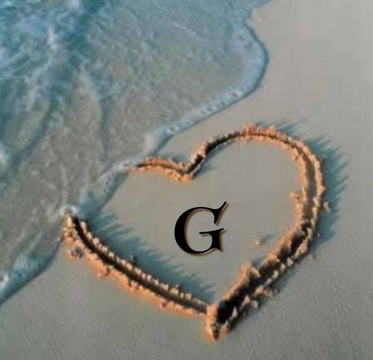 the letter s is in the shape of a heart on the sand at the beach