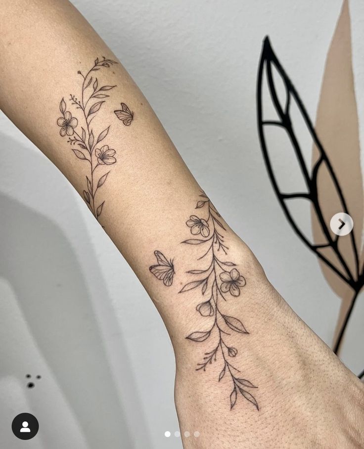 a woman's arm with flowers and leaves on the left side of her arm