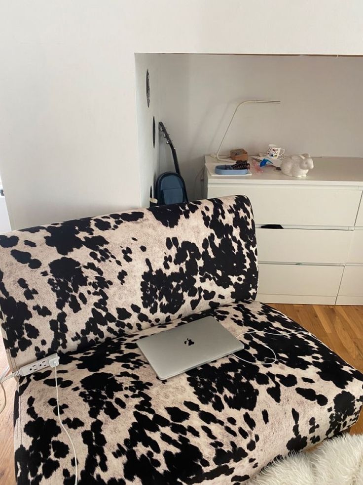 an animal print couch with a laptop on it