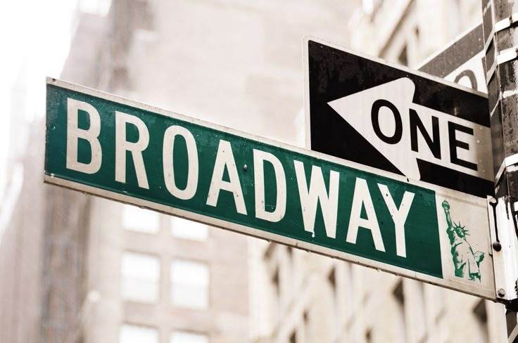 two street signs on the corner of broadway and guas travel in new york city