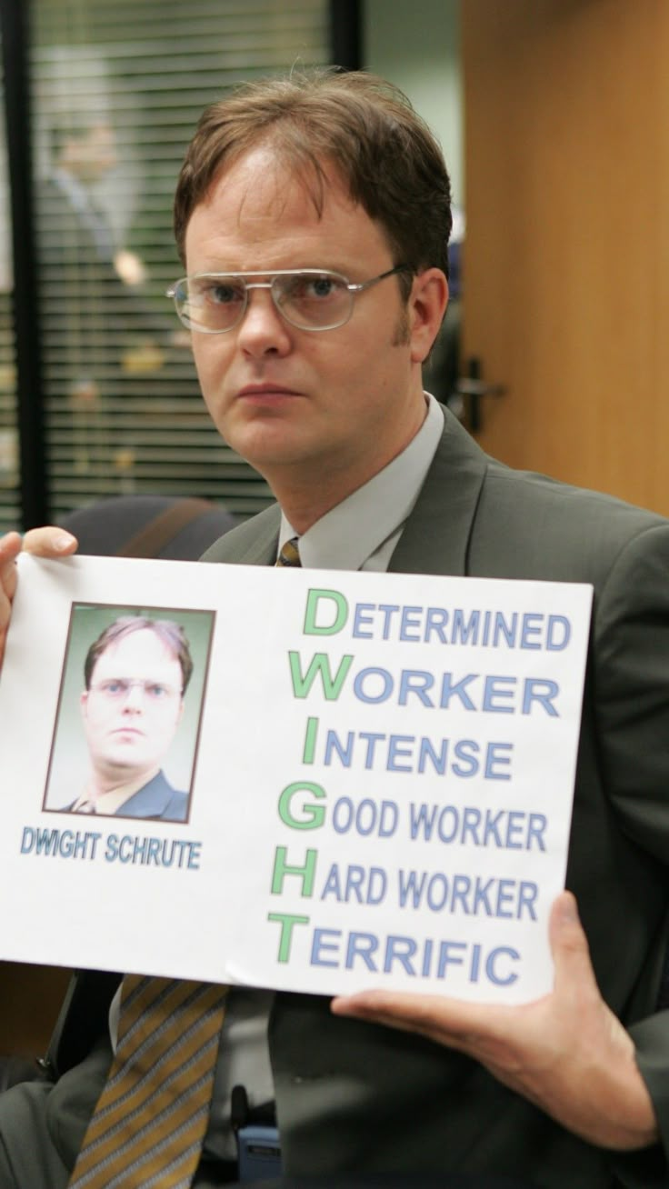 a man holding up a sign that says determined worker intense good worker hard worker terrible