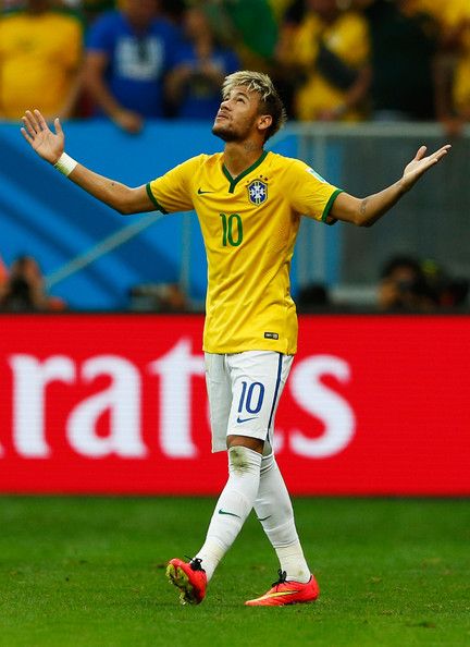 a soccer player with his arms out in the air while looking up at the sky