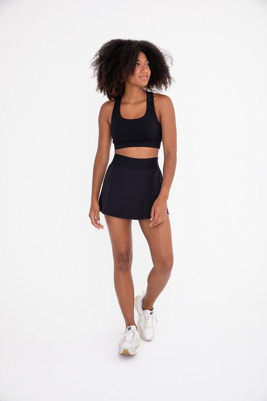 The perfect skirt for on and off the court! It features a seam that swoops all the way around, a thick elastic waistband, and built-in shorts with side pockets. Fabric & fit: 88% nylon 12% spandexMoisture-wickingFour-way stretch Model is wearing size Small. Hiking Leggings, Pole Shorts, Graphic Leggings, Tennis Skort, Bootcut Pants, Clothing Retail, High Rise Shorts, Short Leggings, The Court