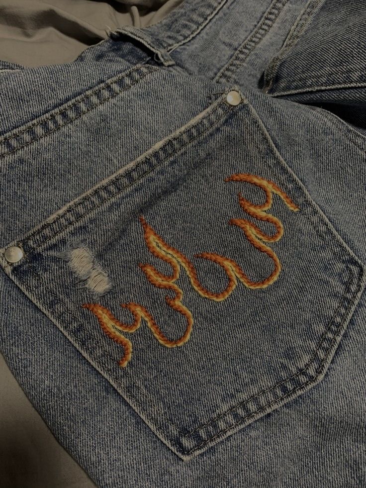 an old pair of jeans with embroidered words on the back pocket and side pockets that say easy