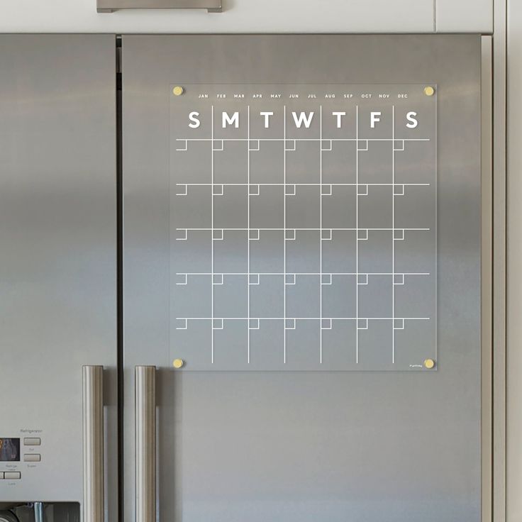 a stainless steel refrigerator with a magnet on the door that says smtwtfs