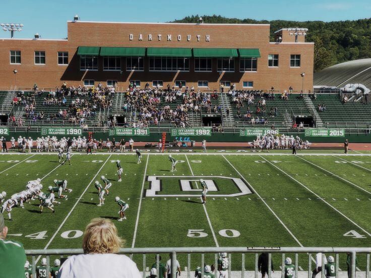 a football game is being played in front of an empty bleachers with people sitting on the bleachers watching