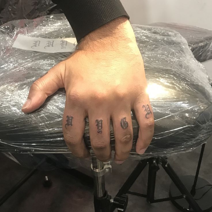 a person with two tattoos on their fingers and one has the word love tattooed on his left hand