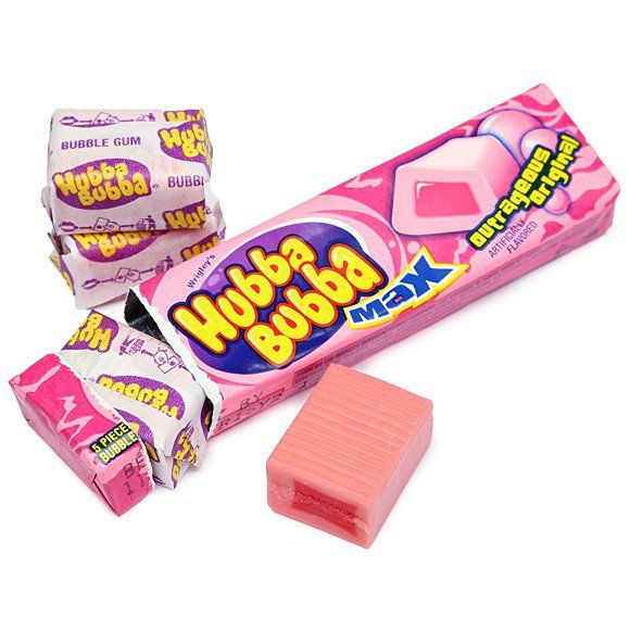 a pink gummy bar next to some candy bars