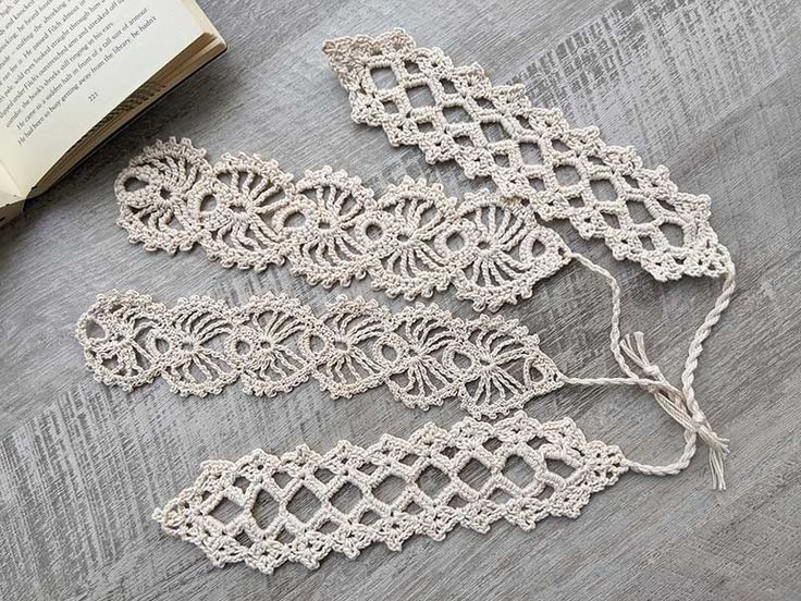 crocheted lace on the floor next to an open book