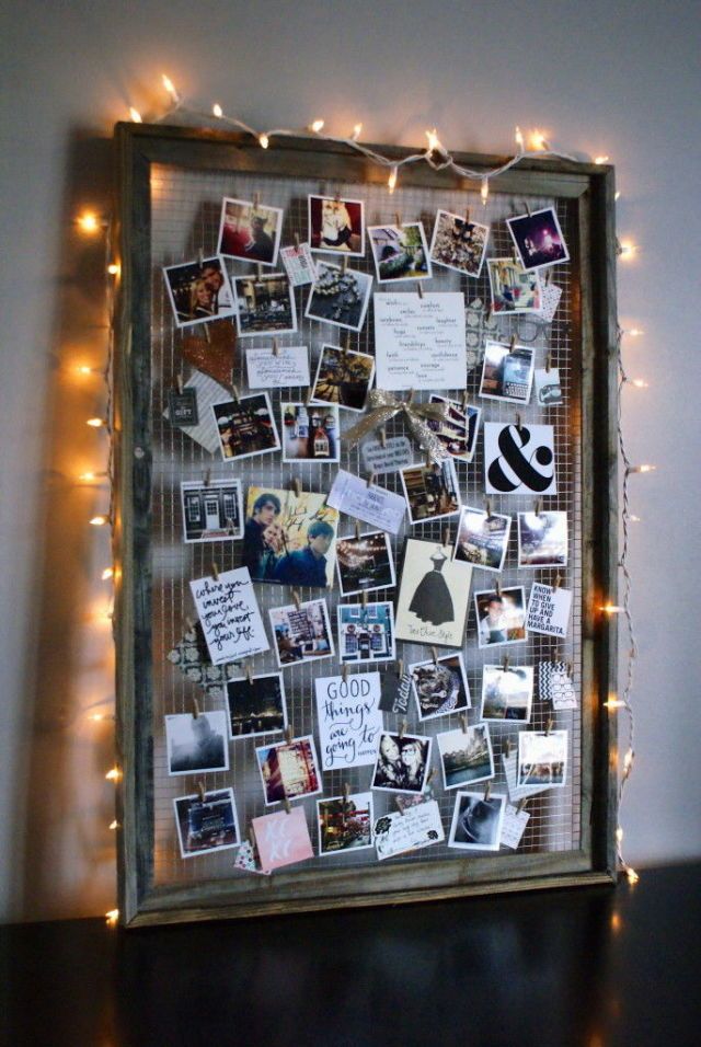 an image of a bulletin board with pictures on it and lights strung around the frame