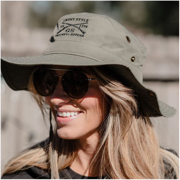 The Grunt Style Boonie Hat is the perfect accessory for any outdoor adventure in the summertime. Whether you're going on a hike, camping, or just spending a day outdoors, this Boonie Hat features a wide brim that will keep the sun off your face and neck to protect you from the elements. It is lightweight and comfortable with an adjustable chin strap to ensure a secure fit. One size fits most. Boonie hat with drawstring Polyester ripstop fabric Center front embroidery Metal eyelets Screen printed Military Style Bucket Hat For Outdoor, Military Style Brimmed Sun Hat For Outdoor, Adjustable Military Style Sun Hat For Outdoor, Upf 50+ Brimmed Hats For Hiking, Adjustable Military Bucket Hat For Camping, Grunt Style, Ripstop Fabric, Summer Adventures, Wide Brimmed