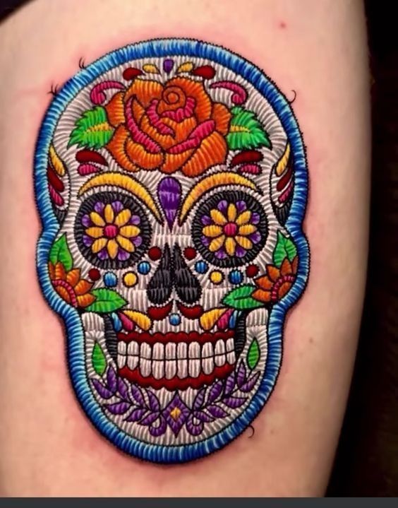 a colorful sugar skull tattoo on the thigh