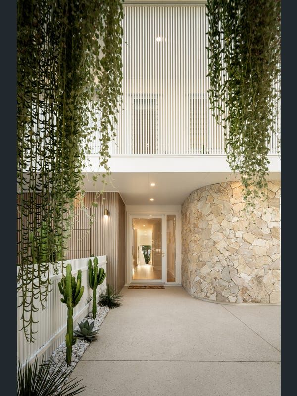 an entrance to a house with plants growing on the wall