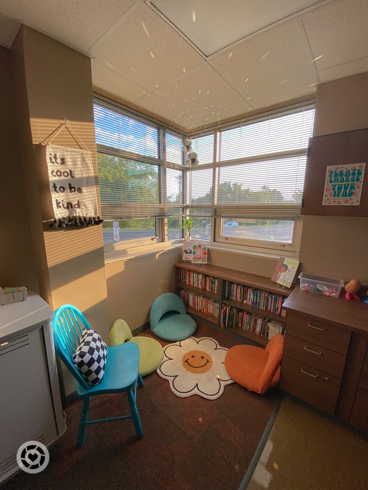 a room with lots of books and toys on the floor next to a window that looks out onto a body of water