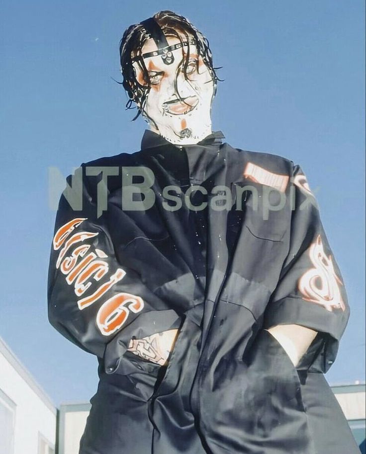 a man with his face painted in black and white is posing for the camera while wearing a baseball uniform