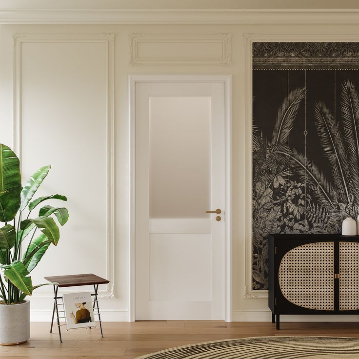 a living room with white walls and wooden flooring, a large plant in the corner