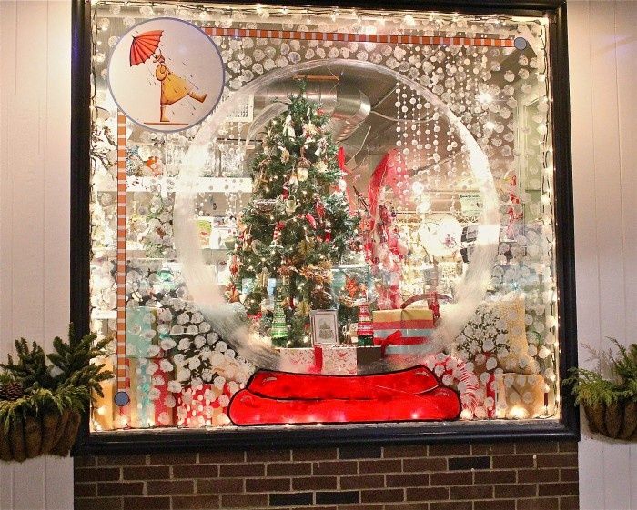 a snow globe with a christmas tree in the center and presents under it on display