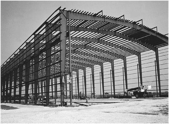 a black and white photo of a large building with lots of metal beams on it