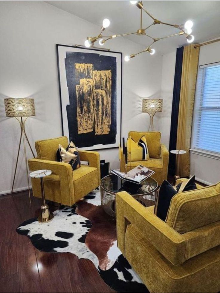 a living room filled with yellow chairs and black and white rug on top of a hard wood floor