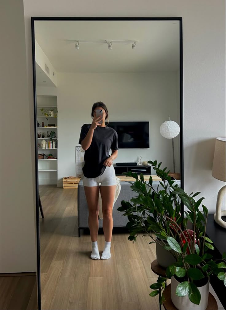 a woman taking a selfie in front of a mirror