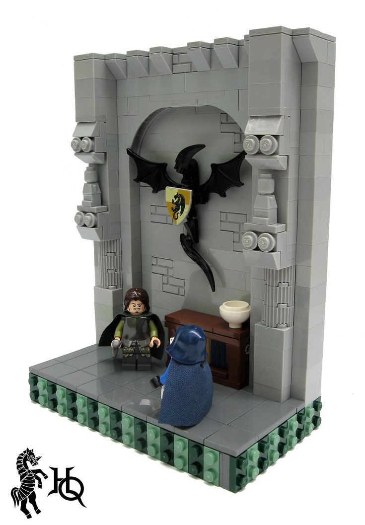 a lego castle with two figurines sitting on the floor and one is holding a bat