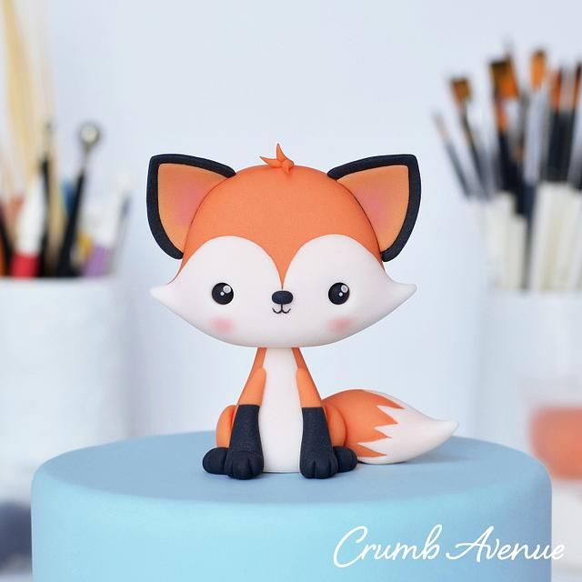 a close up of a cake with a figurine of a fox on top