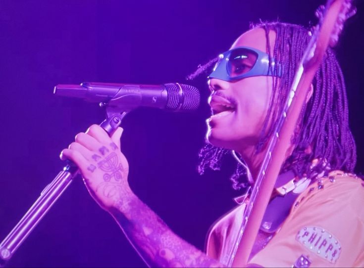 a man with dreadlocks singing into a microphone