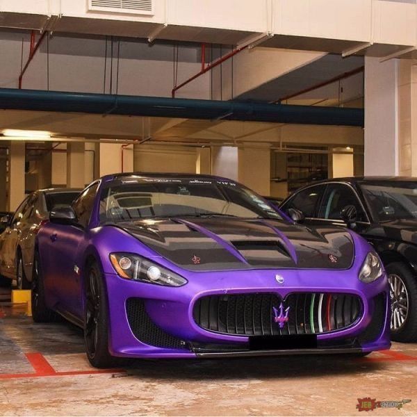 two purple sports cars parked next to each other in a parking garage