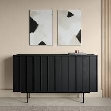 two paintings hang on the wall next to a black credenza with metal legs