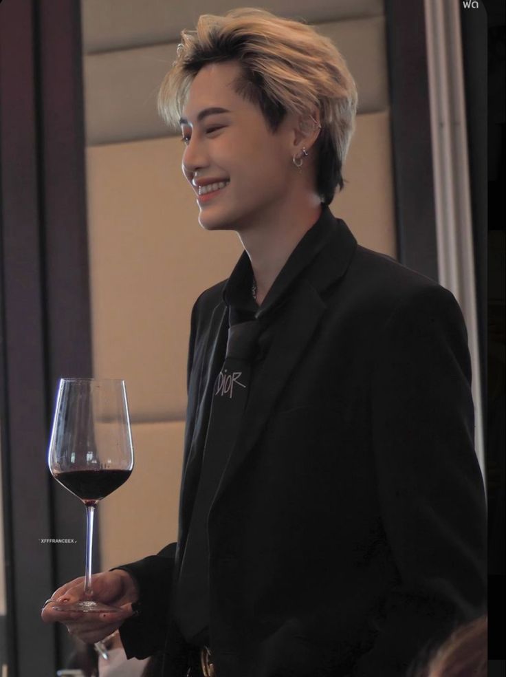 a young man holding a glass of wine