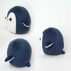 three blue stuffed animals sitting next to each other on a white surface with one penguin facing the camera