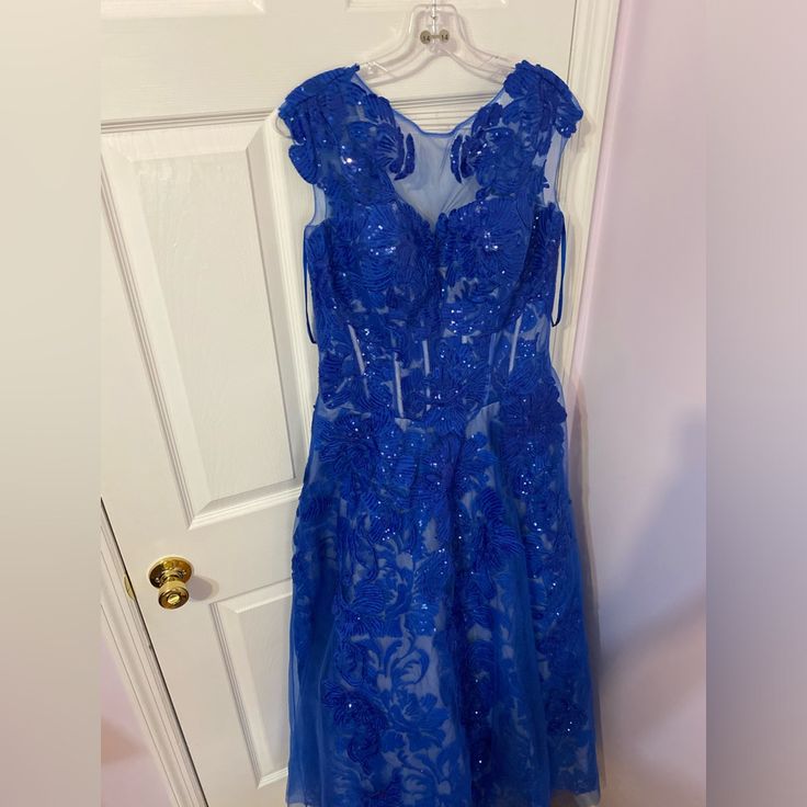 a blue dress hanging on a white door