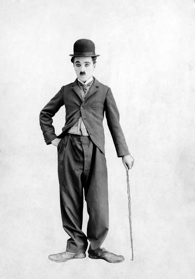 a black and white photo of a man in a top hat holding a cane with his hands on his hips