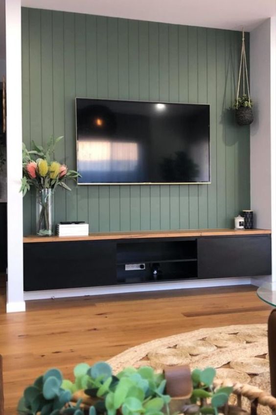 a large flat screen tv mounted to the side of a wall in a living room