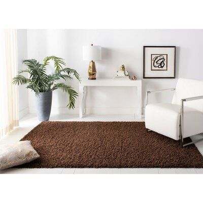 a living room with white furniture and a brown rug