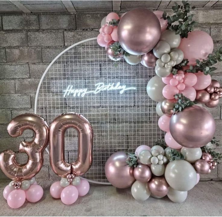 balloons and decorations are arranged around the number 30 sign in front of a brick wall