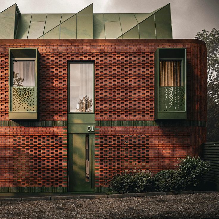 a red brick building with green shutters on the front and windows in the side