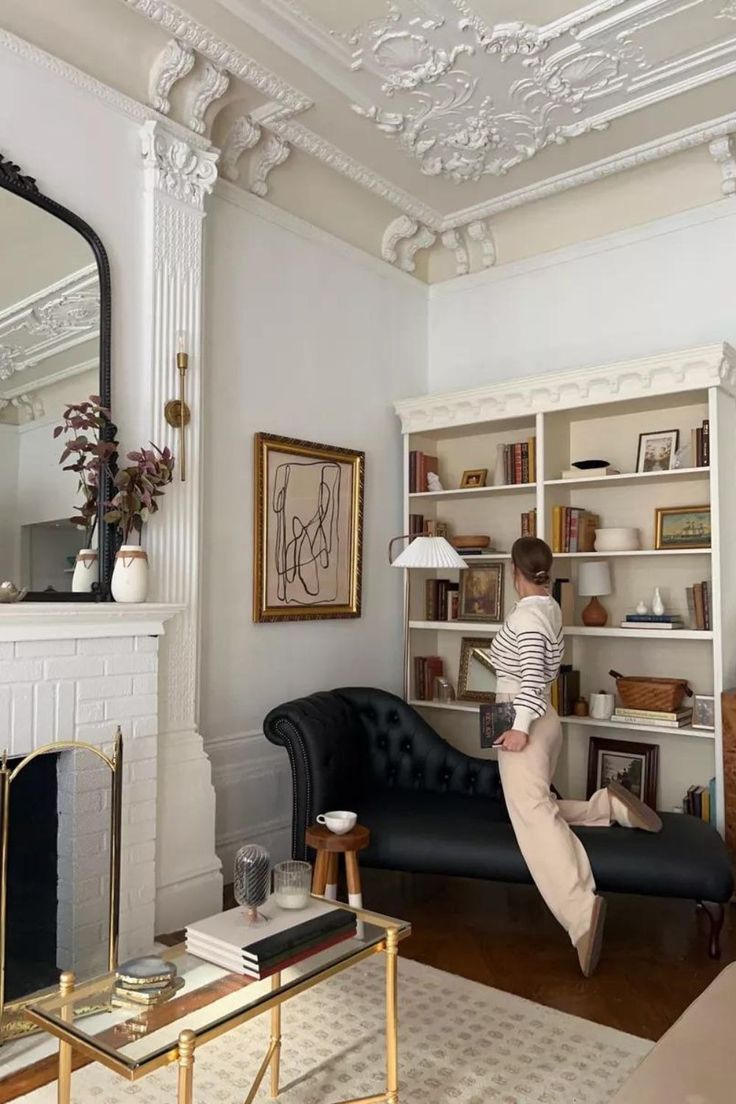 Studio/living room design. My little reading nook- black, leather shoes, gold floor, lamp with pleated lamp, shade, gold, framed, black and white, abstract, painting, print, brawl, word, pedestal, bust sculpture, statue, side table, stool, glass, rectangular, coffee, table, gold, neutral, checkered rug, can send velvet sofa couch Georgetown Homes Interior Design, Parisian Haussmann Style, Two Story Living Room Wall Moldings, Parisian Home Aesthetic, Parisian Lighting, Parisian Home Office, Classic Maximalist, Apartment Vintage, Savannah House