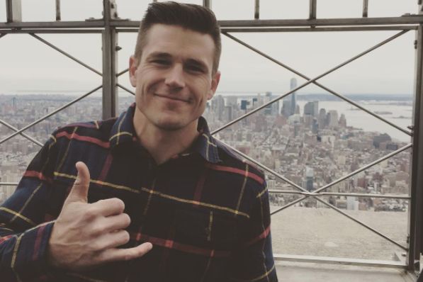 a man giving the thumbs up sign in front of a cityscape with a view