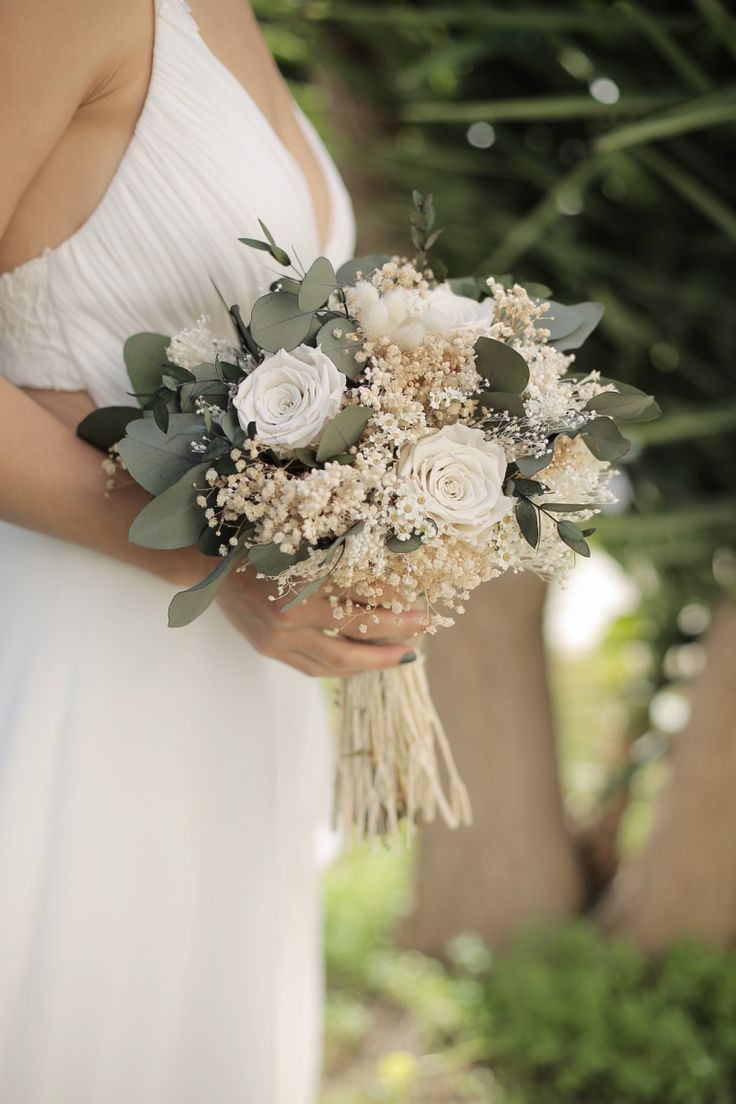 a woman holding a bouquet of flowers in her hands