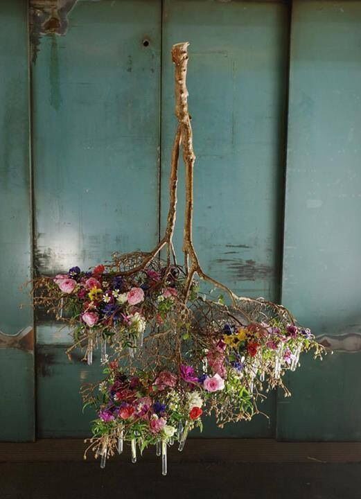 an arrangement of flowers hanging from the ceiling