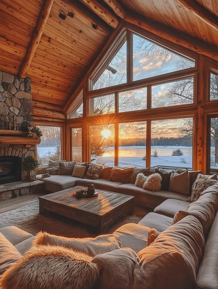 a living room filled with furniture and a fire place in front of a large window